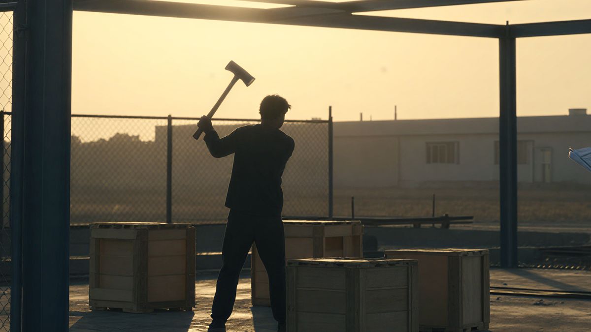 A figure swinging a hammer among stacked crates on an open steel frame.